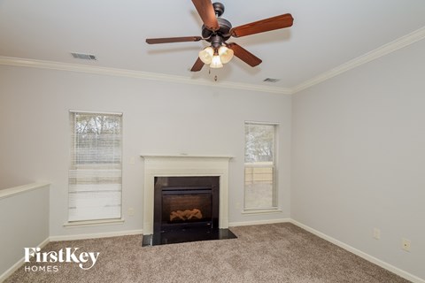 a living room with a ceiling fan and a fireplace