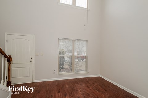 a bedroom with white walls and a window and a door