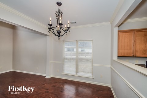 a dining room with a large window and a chandelier