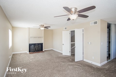 a living room with carpet and a ceiling fan