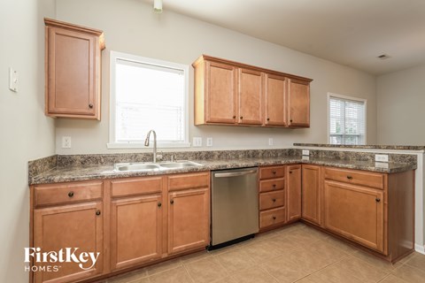 A kitchen with wooden cabinets and a granite countertop.