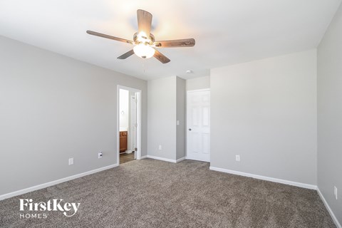 a living room with a ceiling fan and a carpet