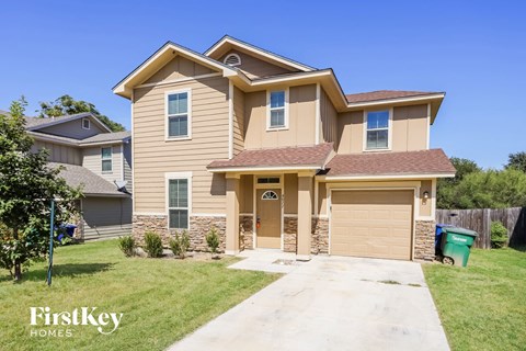 a tan house with a driveway and a garage door
