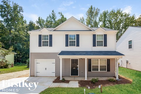 a white house with a black roof and a white garage door