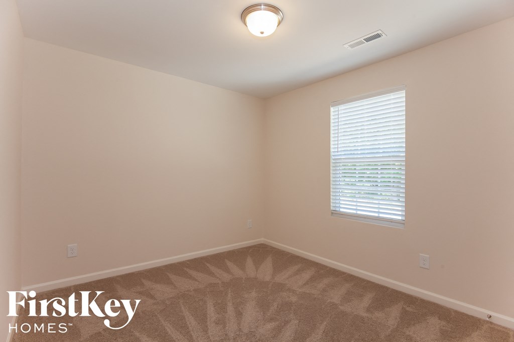 a bedroom with a carpeted floor and a window