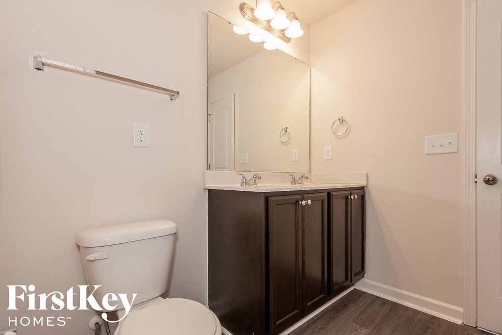 a bathroom with a toilet and a sink and a mirror