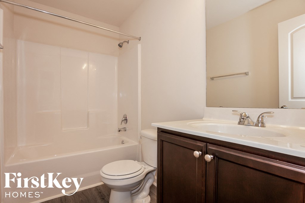 a bathroom with a toilet and a sink and a bath tub