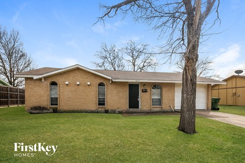A brick house with a tree in front of it.