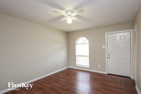 A room with a wooden floor and a ceiling fan.