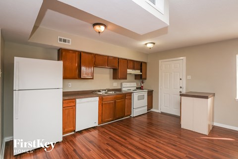 A kitchen with wooden cabinets and a white refrigerator.
