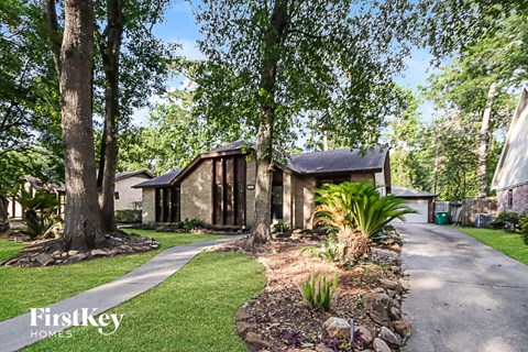 a house with a sidewalk and trees in front of it