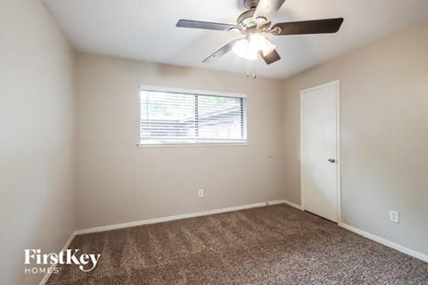 a bedroom with a ceiling fan and a window