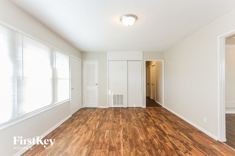 a living room with a hard wood floor and white walls