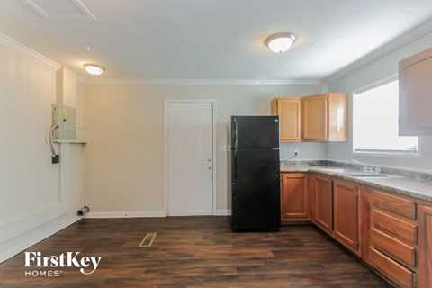 a kitchen with wooden cabinets and a black refrigerator