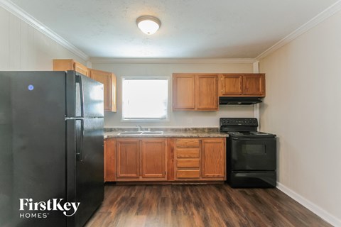 a kitchen with wooden cabinets and a black refrigerator