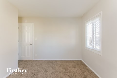 a bedroom with a carpeted floor and a white door