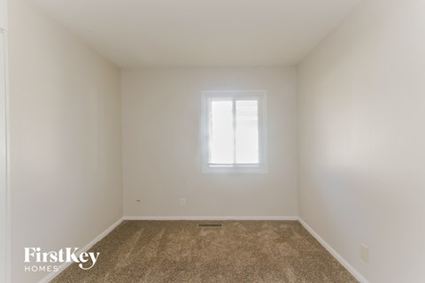 a small room with white walls and a window