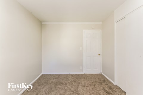 a bedroom with a carpeted floor and a white door