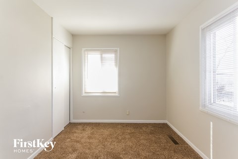 a empty room with a carpet and a window