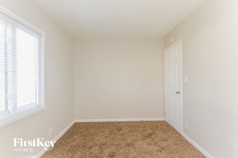 a bedroom with a carpeted floor and a white door