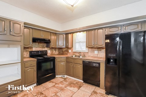 A kitchen with brown cabinets and black appliances.