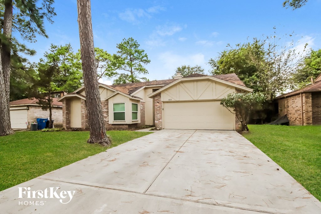 a garage with a driveway and a house with green windows