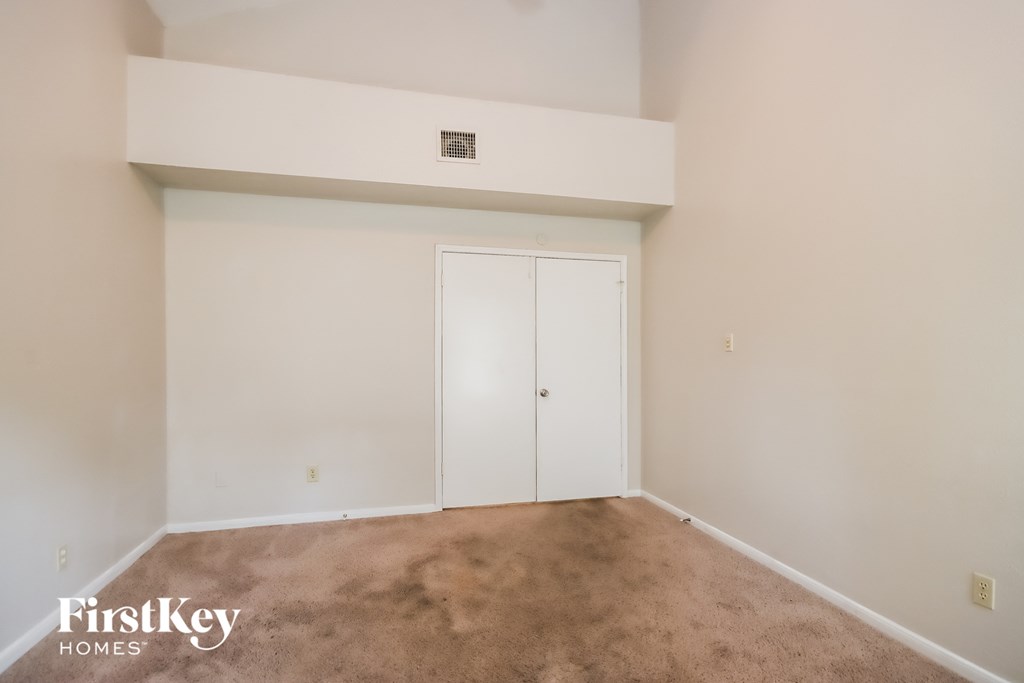 a living room with a carpet and a closet