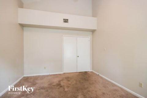 a living room with a carpet and a closet