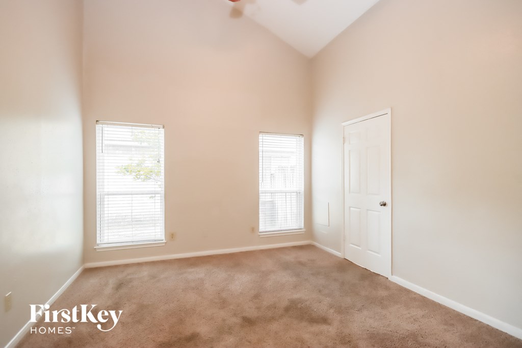 an empty room with two windows and a door