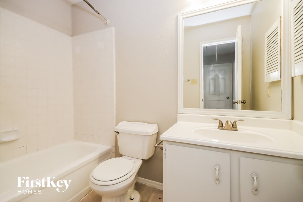 a bathroom with a toilet and a sink and a mirror