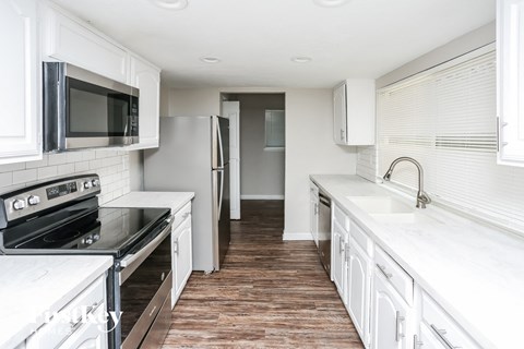 A kitchen with white cabinets and a black stove top oven.
