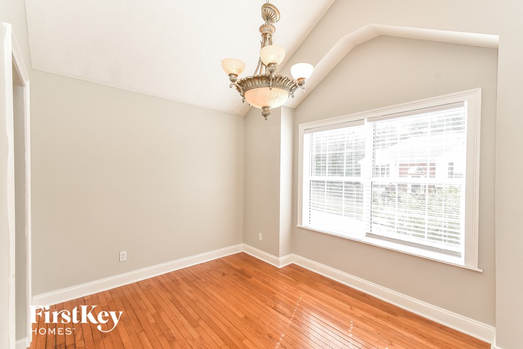 the living room of a home with wood floors and a large window