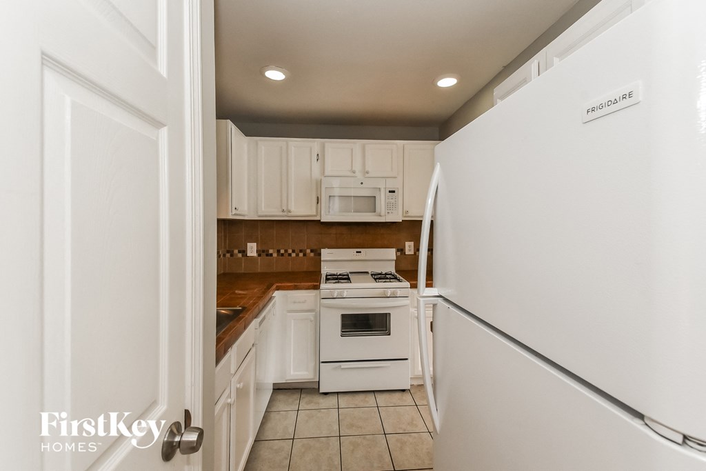 a kitchen with white appliances and white cabinets