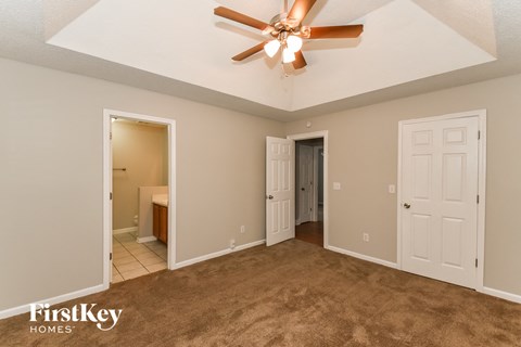 a living room with carpet and a ceiling fan