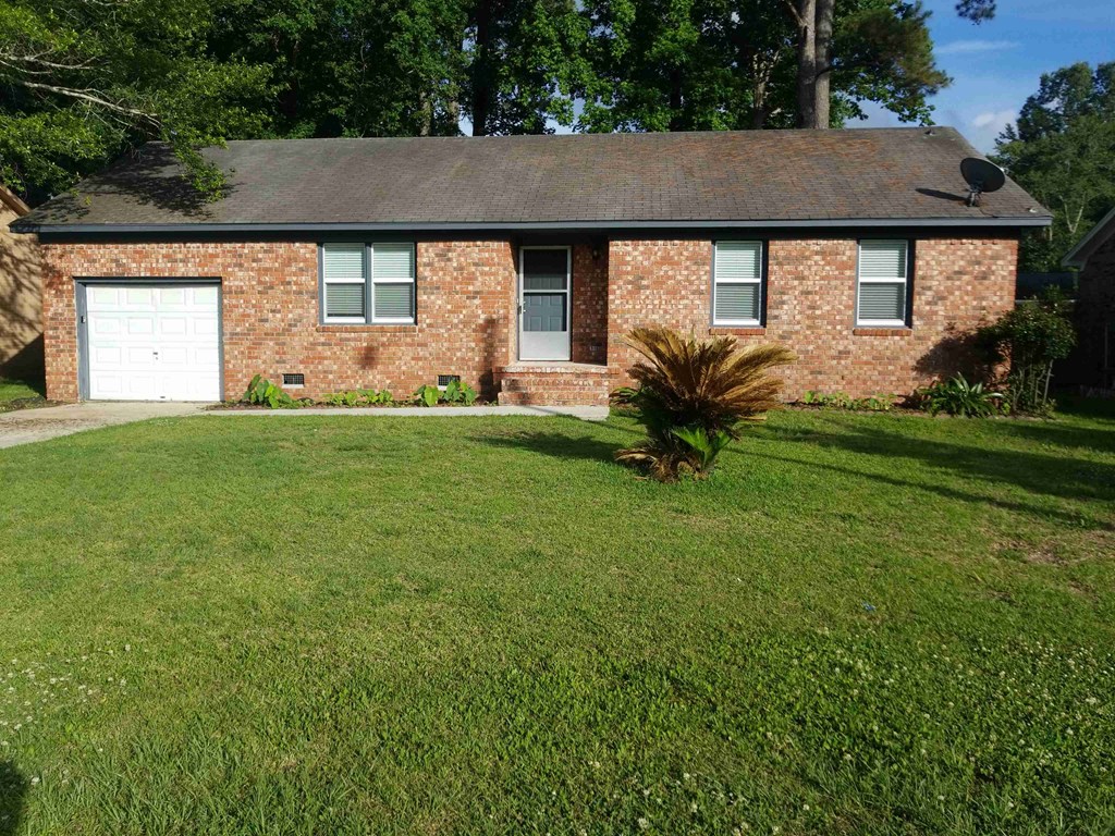 A house with a white garage door and a brick facade.
