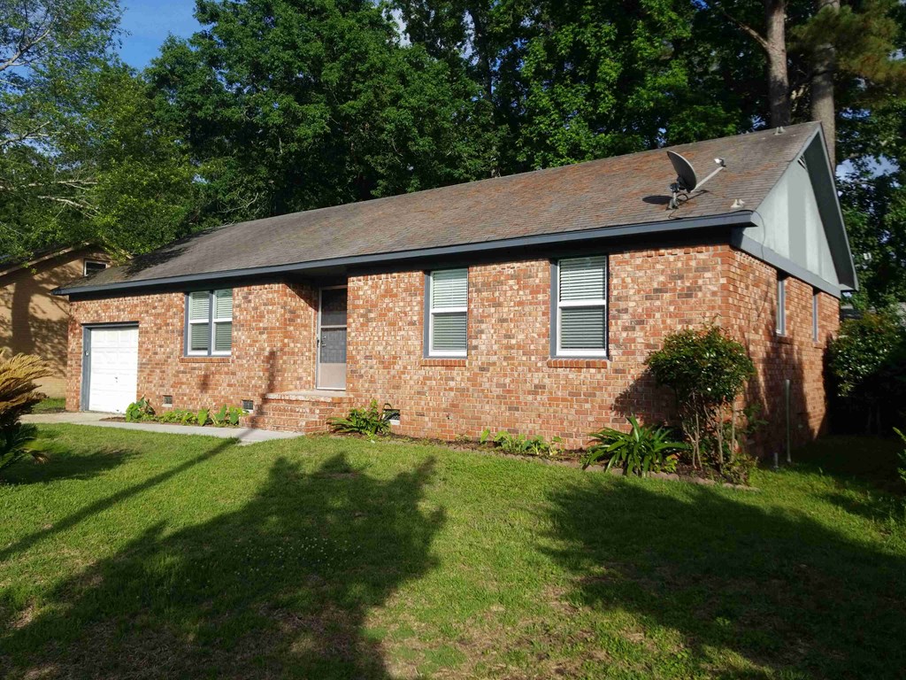 A red brick house with a white door and a small porch.