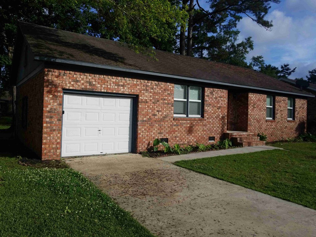 A brick house with a white garage door.