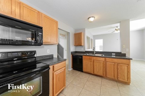 A kitchen with wooden cabinets and black appliances.