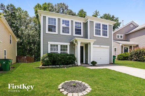 a home with a lawn and a sidewalk in front of it