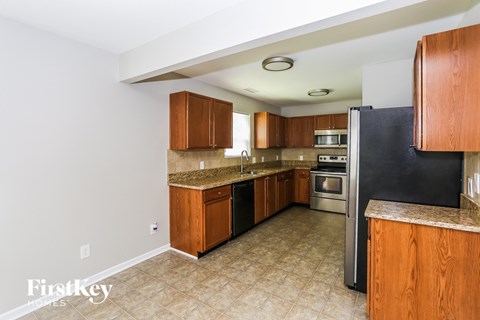 a kitchen with wooden cabinets and a black refrigerator