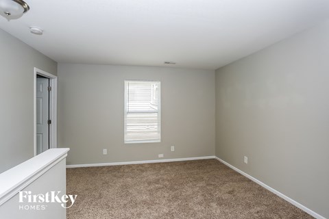 a bedroom with a carpeted floor and a door to a closet