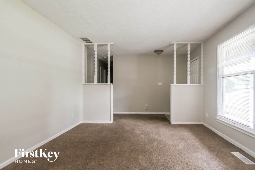 a living room with a carpeted floor and a large window