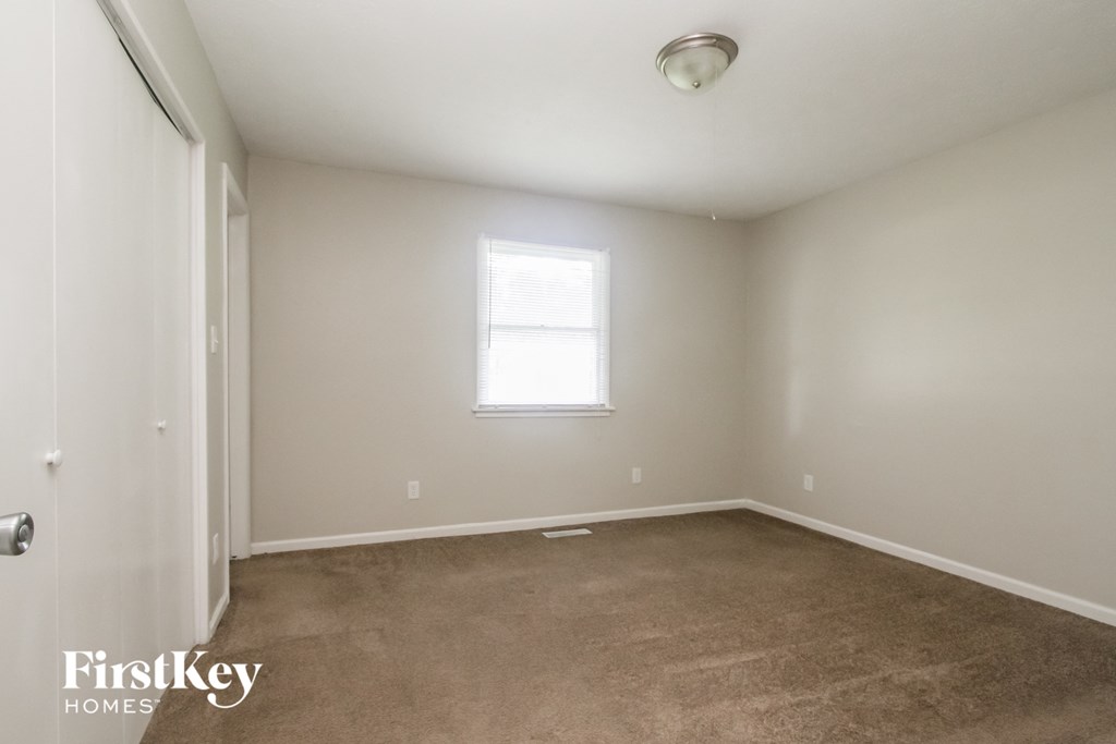 a bedroom with a carpeted floor and a window
