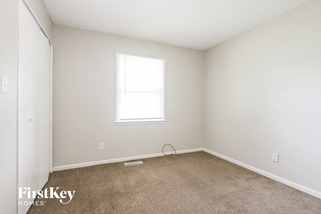 a bedroom with a carpeted floor and a window