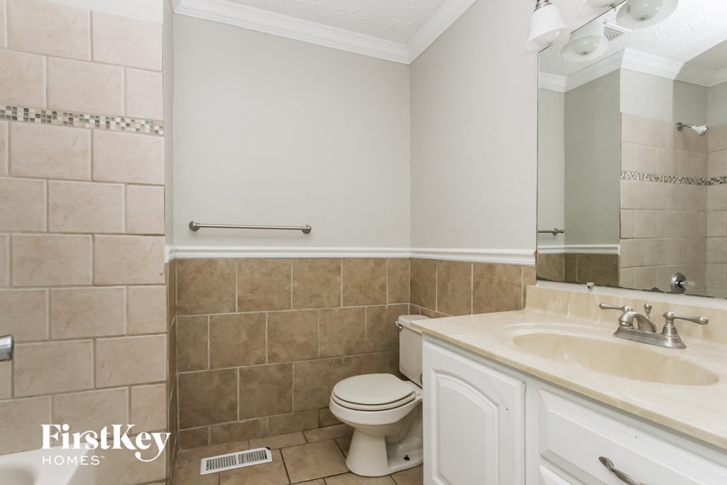 a bathroom with a toilet and a sink and a mirror