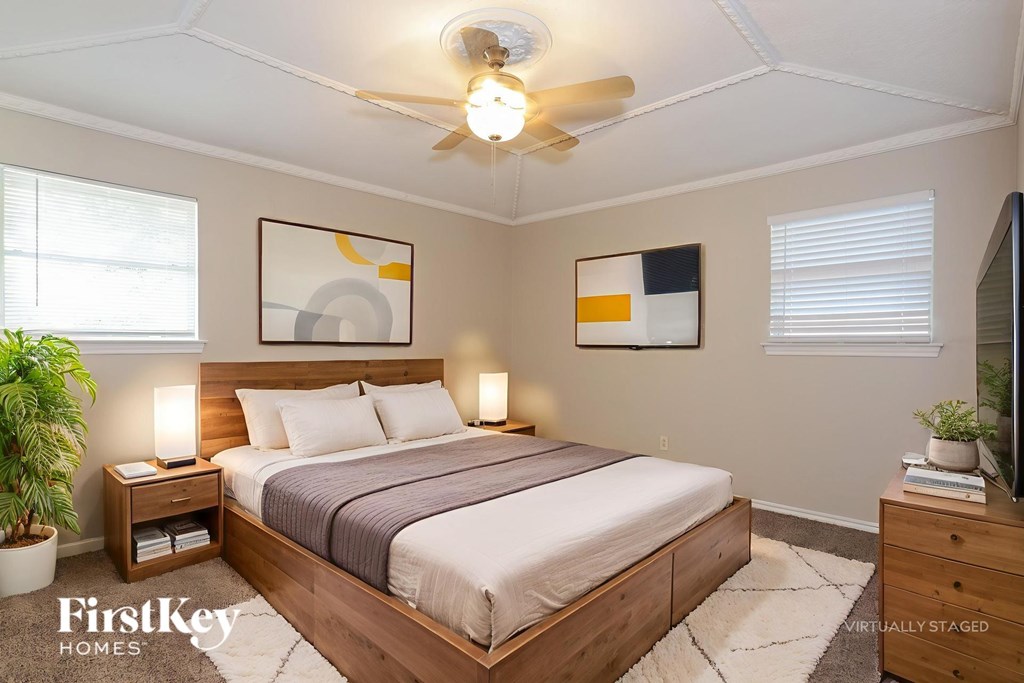 A bedroom with a bed, nightstands, and a ceiling fan.