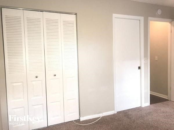 Closet with white doors and a white wall.