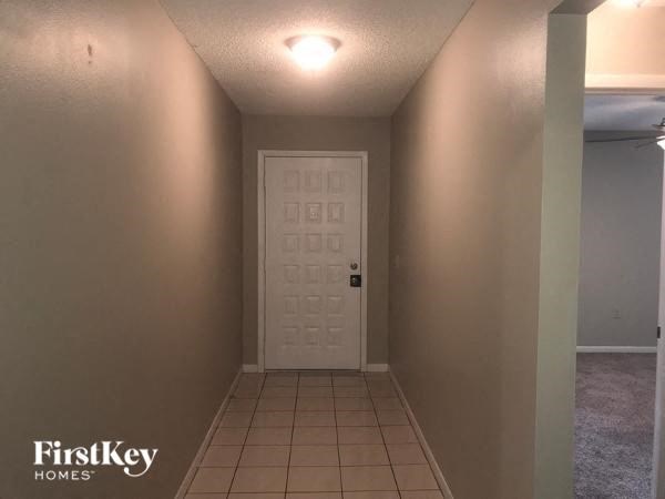 A white door in a hallway with a FirstKey Homes logo.