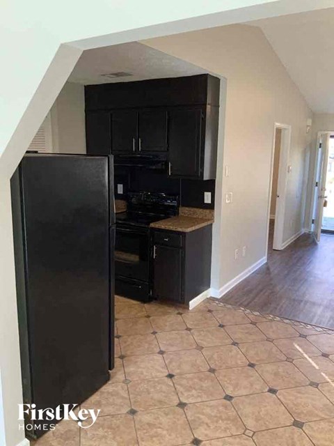 A kitchen with black appliances and cabinets in a house.