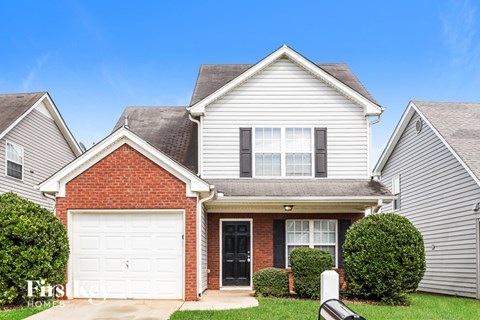 A house with a red brick facade and a white garage door.